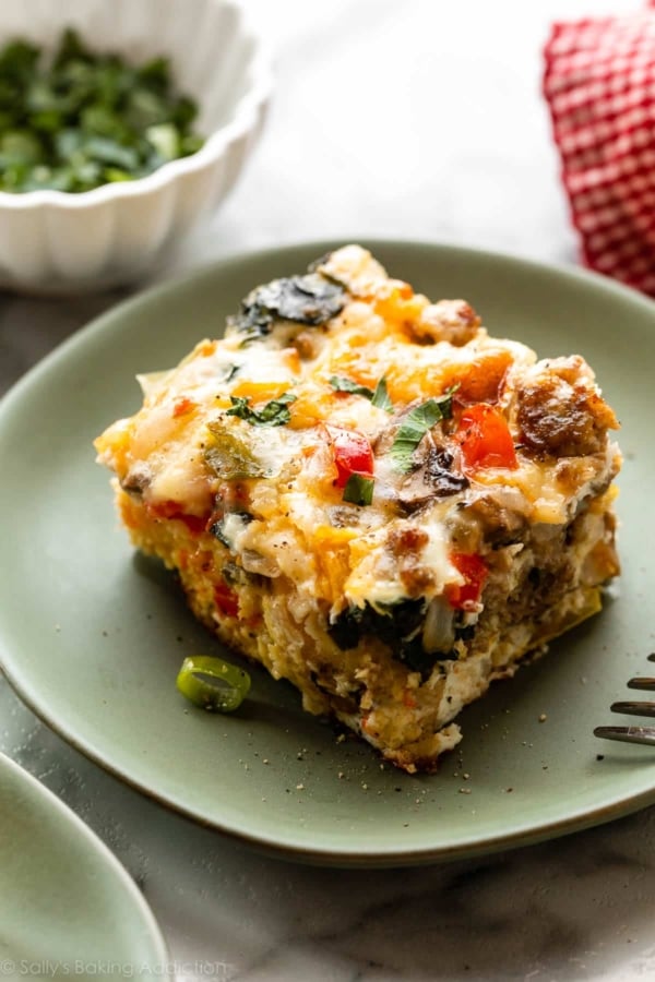 slice of egg and sausage breakfast casserole on green plate.